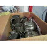 A box containing pewter teapots and tankards