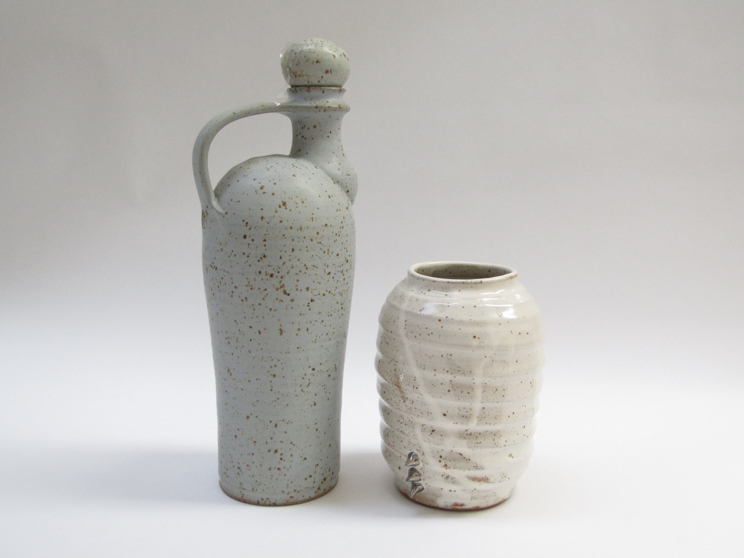 A studio pottery stoneware flask with handle and stopper with ash glaze and iron oxide spotting,