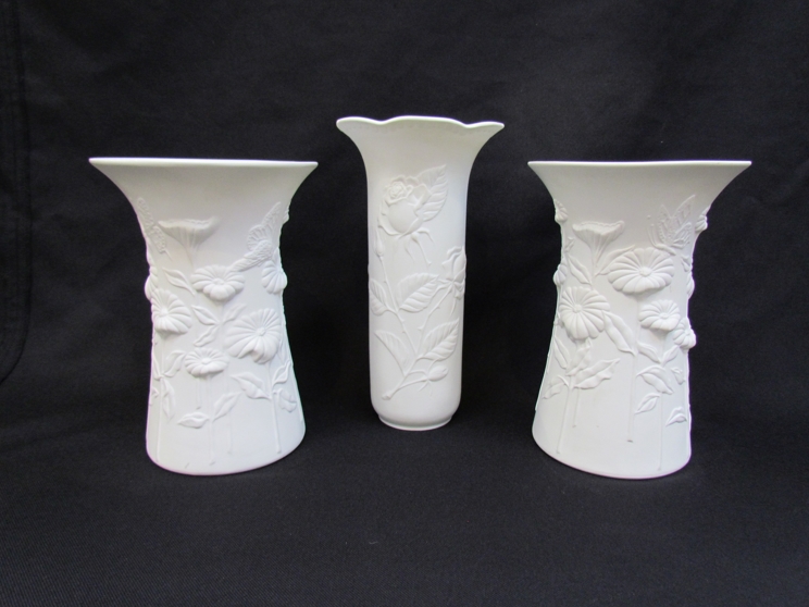 A pair of Kaiser porcelain white matte vases with relief moulded flowers and butterflies, No.