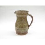 PETER ARNOLD (XX): An Alderney Pottery jug with green and brown speckled glaze. Impressed seal. 17.