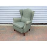 A Danish 1940s wing backed armchair, original green wool upholstery,