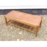A Remploy teak and tiled top metamorphic coffee table with sliding top revealing tiled lower tier,