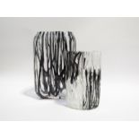 Two art glass vases in clear glass with applied random strapping in black and white.
