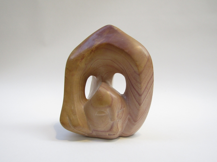 T.A OKARI (XX): A Kenyan carved and polished stone sculpture of stylised figural form.