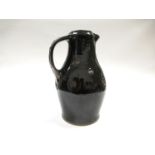 JIM MALONE (b.1946): A Burnby Pottery jug, tenmoku glaze over cross motif decoration.