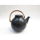 An Arabia tea pot in black glaze designed by Ulla Procope, Cane handle. 15cm high to top of lid.