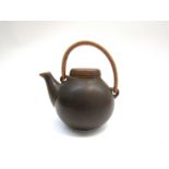 An Arabia brown glazed small teapot by Ulla Procope. Cane handle. 11.