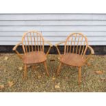 A pair of Ercol elm wood Windsor armchairs.