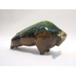 A 1950's pottery stylised figure of a bull in green and ochre glazes unmarked.