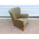 A Danish 1940s oak framed armchair with original green foliate embossed upholstery,