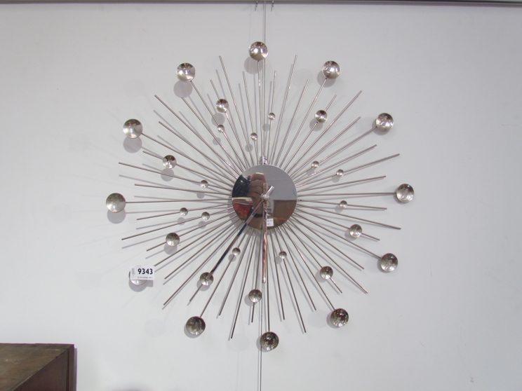 A metal sunburst style wall clock.