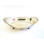 A Robert Pringle and Sons silver wavy edge oval dish on scroll feet.
