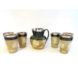 A set of six Doulton Lambeth beakers with silver rims and a matching jug,