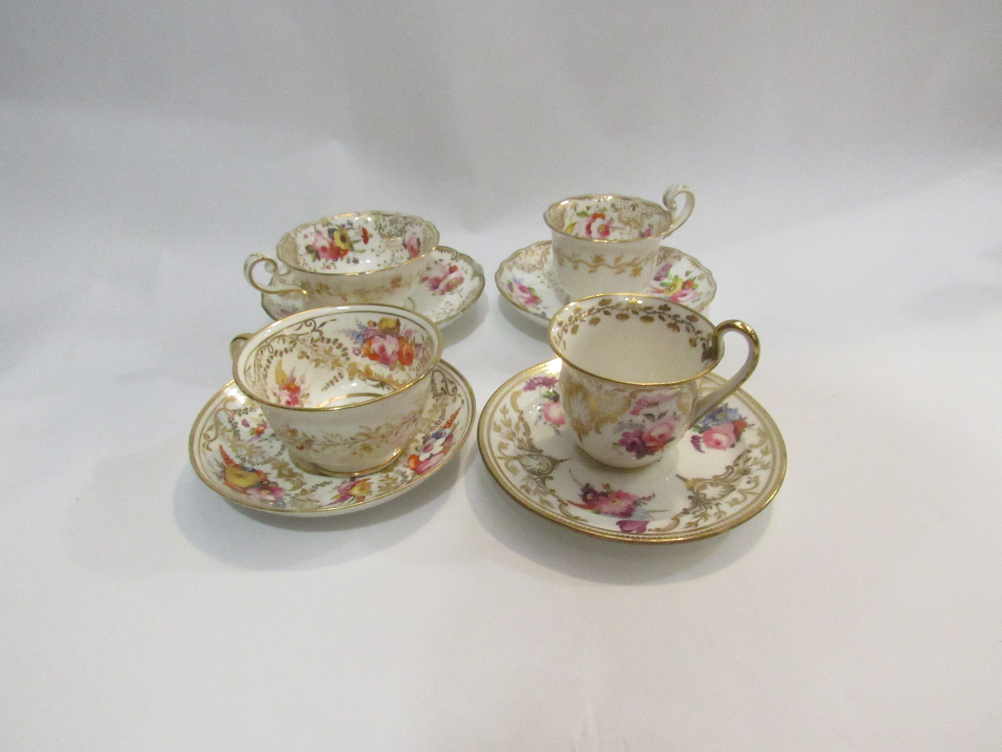 Four late 18th/early 19th Century cups and saucers, white ground with gilt and floral detailing.