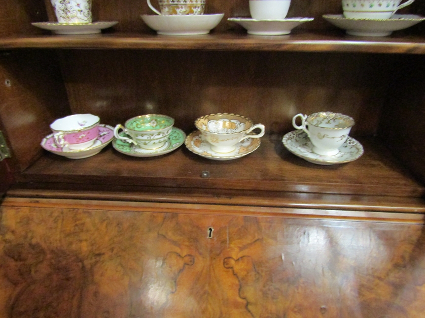 Four late 18th/early 19th Century cups and saucers, various colours with gilt floral detailing,