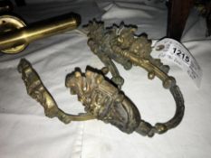 A pair of antique brass curtain tie backs with floral brass work.