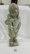 A weathered statue of a girl with doll signed D Torrioni, 13" tall.