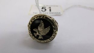 A gentleman's 9ct gold ring with a gold eagle inserted into an onyx base, gold open work shoulders,