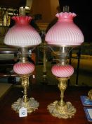 A pair of Victorian peg font oil lamps on ormolu brass candlesticks (one shade chipped and burners