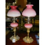 A pair of Victorian peg font oil lamps on ormolu brass candlesticks (one shade chipped and burners