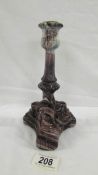 A Victorian pressed purple candlestick on three feet, each with the face of some creature,