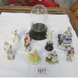 A selection of small continental porcelain figures and a small glass dome.