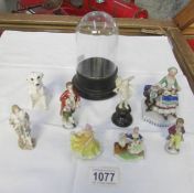 A selection of small continental porcelain figures and a small glass dome.