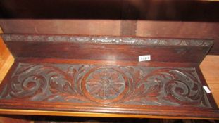 A carved oak wall shelf.