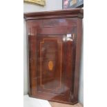 A mahogany inlaid corner cupboard.