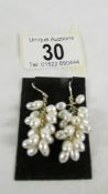 A pair of pearl pendant earrings fashioned as bunches of grapes.