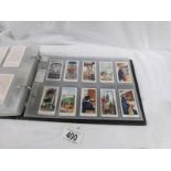 An album containing 11 sets of 1930's cigarette cards, Player's, Wills, Gallaher.