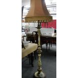 A wooden painted standard lamp with shade.