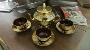 An Italian Venetian gilded ruby red part tea set with floral motif.