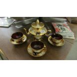 An Italian Venetian gilded ruby red part tea set with floral motif.