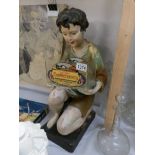 An Advertising figure of a boy holding a glass tank for W A Graves, Louth, Confectionery.