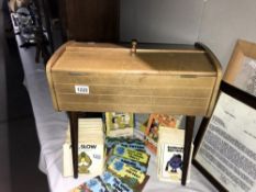 A vintage sewing box containing reels of cotton and other needlework items.