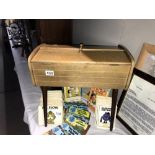 A vintage sewing box containing reels of cotton and other needlework items.