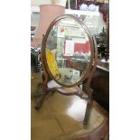 An oval mahogany framed toilet mirror.