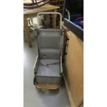 A vintage metal folding pushchair that folds in to a carry case.