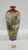 A Victorian hand painted vase depicting 2 cows in a field with a background of mountains signed H