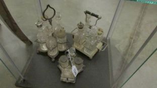 3 silver plate cruets with glass bottles.