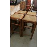 4 wooden bar stools with string seats.