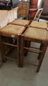 4 wooden bar stools with string seats.