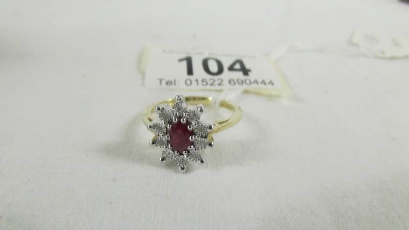 A yellow gold oval ruby and diamond ring, size O.