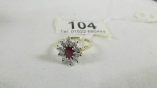 A yellow gold oval ruby and diamond ring, size O.