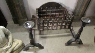 A cast iron fire grate with side stands.