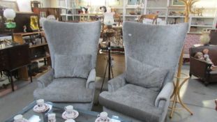 A pair of superb quality high back easy chairs.