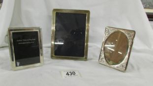 3 silver photo frames with easel stands, 15 x 11 cm, 10 x 7.5 cm and 10.5 cm x 7.5 cm.