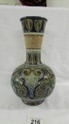 A Doulton Lambeth 25 cm flask vase. Heavily embossed in blue, whites and fawns.