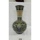 A Doulton Lambeth 25 cm flask vase. Heavily embossed in blue, whites and fawns.